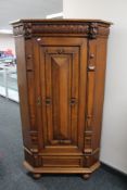 A continental carved oak corner cabinet