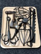 A tray of antique metal ware, cast iron tongs, trivets,