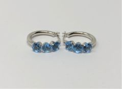 A pair of white gold blue topaz hoop earrings