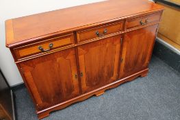 A reproduction yew wood sideboard