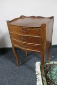 An inlaid mahogany three drawer bedside chest