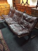 A set of three Scandinavian chairs in Burgundy leather with matching footstool