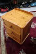 A pine three drawer bedside chest