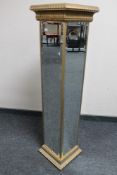A contemporary mirrored pedestal stand
