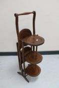 An Edwardian oak folding cake stand