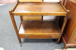 An early twentieth century mahogany tea trolley fitted with a drawer