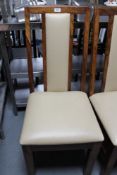 A set of fourteen hardwood cream vinyl dining chairs