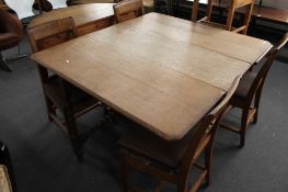 An oak gate leg table and five oak chairs.