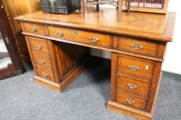 An Edwardian oak pedestal partners desk