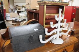 A small painted display shelf, a wooden box and a candleabrum.