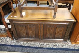 A carved oak linen fold blanket box