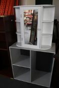 A mirrored bathroom cabinet and a storage cube.
