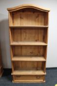 A pine bookcase fitted with a drawer