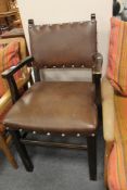 A brown studded leather armchair