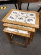 A nest of three tiled oak tables