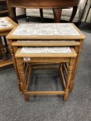 A nest of three tiled oak tables