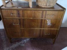 A mid century walnut four drawer chest.