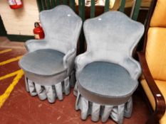 A pair of mid century bedroom chairs in turquoise fabric.