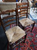 A pair of nineteenth century oak ladder backed country chairs