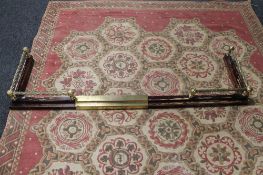 A brass and wooden fire curb