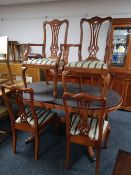 A reproduction yewwood extending table and six chairs
