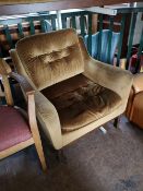 A mid century mustard coloured studded armchair.