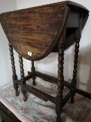 An Edwardian oak flap sided table