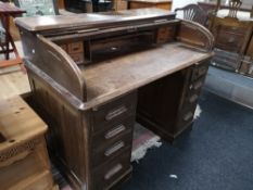 An Edwardian oak roll topped desk