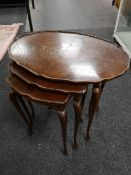 A nest of tables together with a small carved table