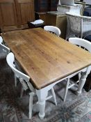 A rustic pine farmhouse table and four painted chairs