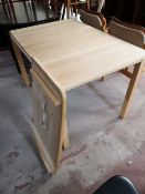 A contemporary extending beech dining table and three high backed chairs.