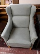 A contemporary turquoise fabric armchair.