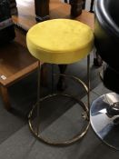 A pair of contemporary bar stools with mustard colour seats