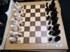 A beech chess board with carved resin pieces