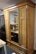 An Edwardian mirrored door wardrobe fitted with a drawer