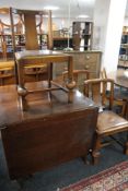 An early 20th century oak flap sided table and three chairs
