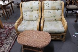 A pair of conservatory chairs and a small wicker low table
