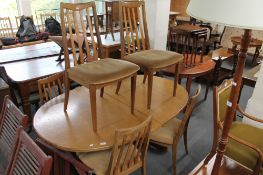 A teak extending dining table and six chairs