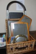 A wicker crate of teak framed mirrors, pictures and prints,