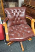 A Burgundy buttoned leather swivel chair