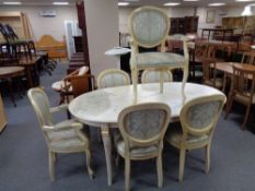An oval cream and gilt continental style dining table and set of six chairs