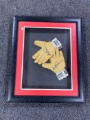 A framed pair of goalkeeper's gloves with signature