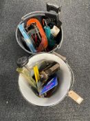 A plastic bucket and an enamel bucket containing assorted hand and power tools