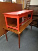 A painted red coffee table together with a further teak coffee table