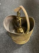 An antique brass coal bucket and companion set
