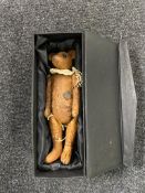 A vintage jointed teddy bear in box