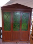 An early twentieth century triple door armoire on bun feet