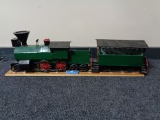 A hand built wooden model of a steam train with carriage