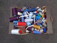 A large plastic tub of zips together with a box of spools of thread