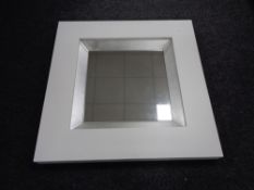 A white contemporary framed mirror CONDITION REPORT: This is 89cm by 89cm by 7.